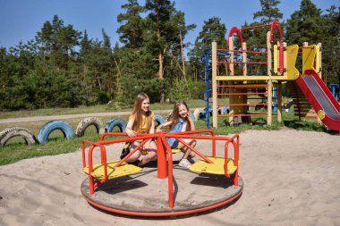 Okul çağındaki çocuklar şehir dışındaki bir çam ormanının yakınındaki bir oyun alanında oynuyorlar. Yaz tatili