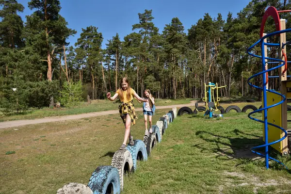Okul çağındaki çocuklar şehir dışındaki bir çam ormanının yakınındaki bir oyun alanında oynuyorlar. Yaz tatili