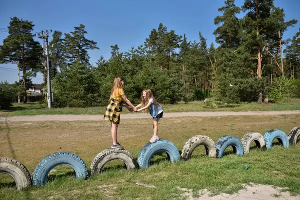 Okul çağındaki çocuklar şehir dışındaki bir çam ormanının yakınındaki bir oyun alanında oynuyorlar. Yaz tatili