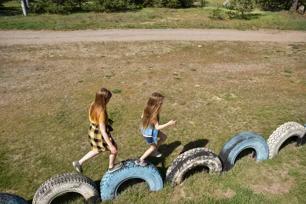 Okul çağındaki çocuklar şehir dışındaki bir çam ormanının yakınındaki bir oyun alanında oynuyorlar. Yaz tatili