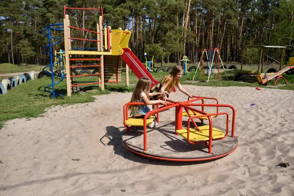 Okul çağındaki çocuklar şehir dışındaki bir çam ormanının yakınındaki bir oyun alanında oynuyorlar. Yaz tatili