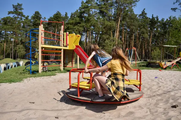 Okul çağındaki çocuklar şehir dışındaki bir çam ormanının yakınındaki bir oyun alanında oynuyorlar. Yaz tatili