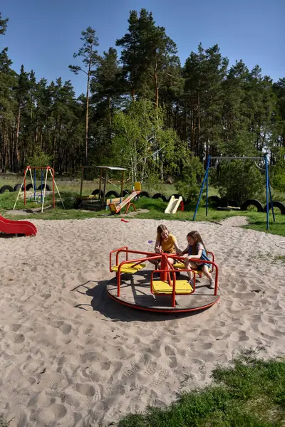 Okul çağındaki çocuklar şehir dışındaki bir çam ormanının yakınındaki bir oyun alanında oynuyorlar. Yaz tatili