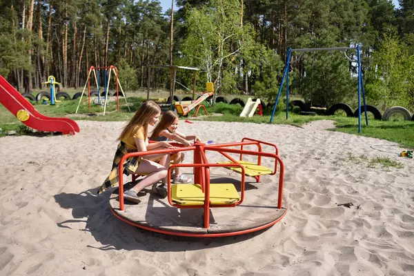 Okul çağındaki çocuklar şehir dışındaki bir çam ormanının yakınındaki bir oyun alanında oynuyorlar. Yaz tatili