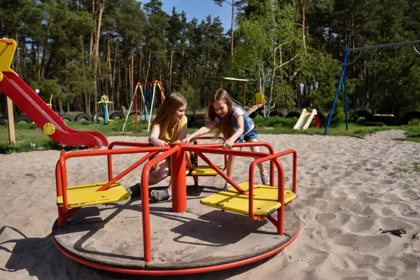 Okul çağındaki çocuklar şehir dışındaki bir çam ormanının yakınındaki bir oyun alanında oynuyorlar. Yaz tatili