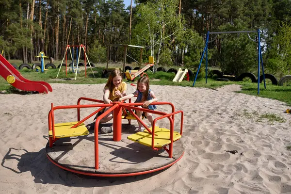 Okul çağındaki çocuklar şehir dışındaki bir çam ormanının yakınındaki bir oyun alanında oynuyorlar. Yaz tatili