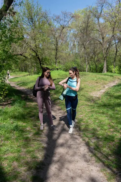 Eşofmanlı iki bayan arkadaş parkta spor yapmak için buluştular.