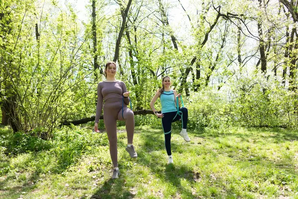 Parkta direniş bandıyla spor yapan iki bayan arkadaş.