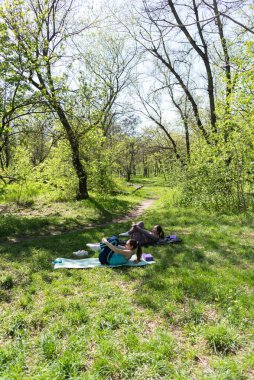 Parktaki minderlerde yoga yapan iki genç kız arkadaş.