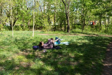 Parktaki minderlerde yoga yapan iki genç kız arkadaş.