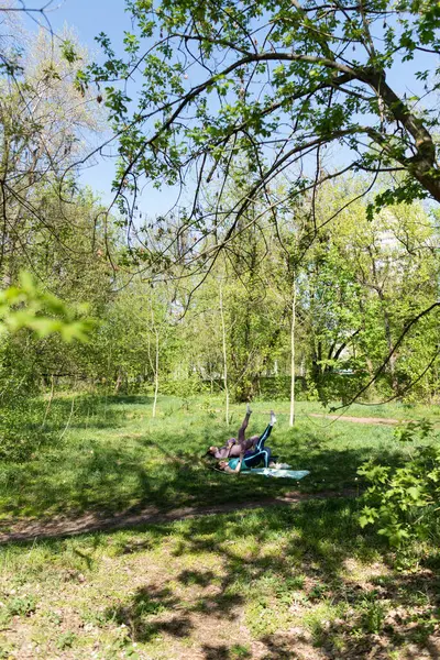 Parktaki minderlerde yoga yapan iki genç kız arkadaş.