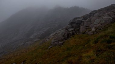 Sisteki kayalık bir dağın dikey görüntüsü.