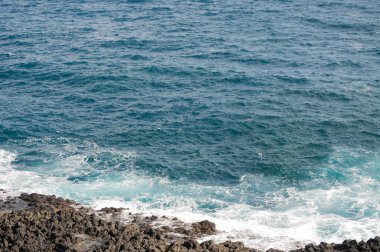 Deniz dalgaları ve kayalar kıyıda