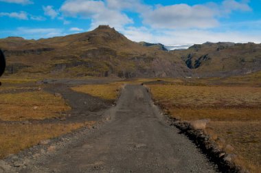 İzlanda 'da bir araba ve bir yol ile güzel bir manzaranın yakın çekimi.