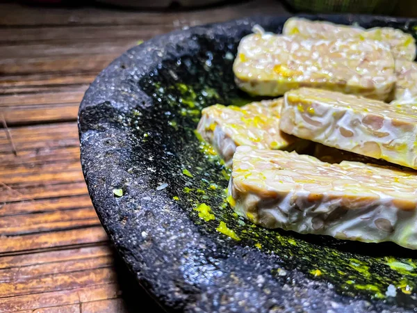 Doğranmış ve pişirilmeye hazır bir tabak Tempeh 'in kapağını kapatın. Taş bir tabakta. Tempeh yüksek protein içeriği, diyet lifleri ve vitaminler. Sabit bir dokusu ve topraksı bir tadı var.