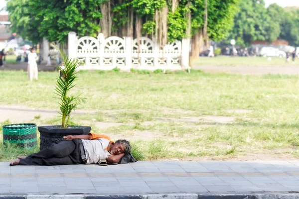 Yogyakarta, Endonezya - 30 Kasım 2022: Yaşlı evsiz bir adam kaldırımda 