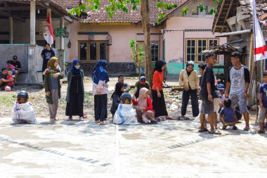 Yogyakarta, Endonezya. 14 Ağustos 2022: Çocuklar kask takıp Endonezya 'nın bağımsızlık gününü kutlamak için çuval yarışı yapıyorlar