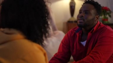 Yakışıklı, Afro-Amerikan genç kocayı seven, tanınmayan karısıyla konuşan, evinde rahat bir oturma odasında oturan. Rahatlamış mutlu adamın portresi evde bir kadınla eğleniyor.