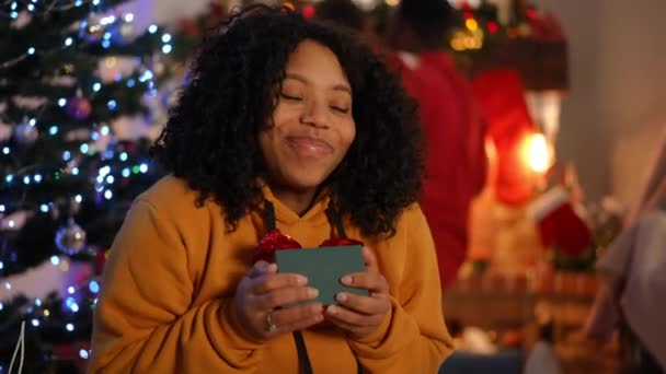 Портрет Щасливої Афроамериканської Дівчини Яка Дивиться Фотоапарат Хвалить Різдвяний Подарунок — стокове відео