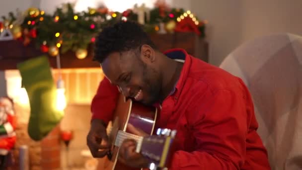 Talentoso Jovem Afro Americano Sorrindo Tocando Guitarra Lareira Sala Estar — Vídeo de Stock