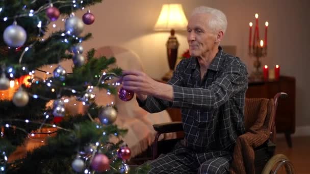 Positieve Oude Man Rolstoel Versieren Kerstboom Thuis Glimlachend Portret Van — Stockvideo