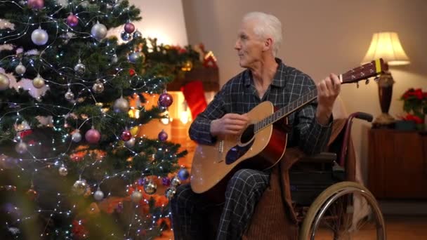 Leende Positiv Senior Man Rullstol Spelar Gitarr Sång Nyårsafton Hemma — Stockvideo