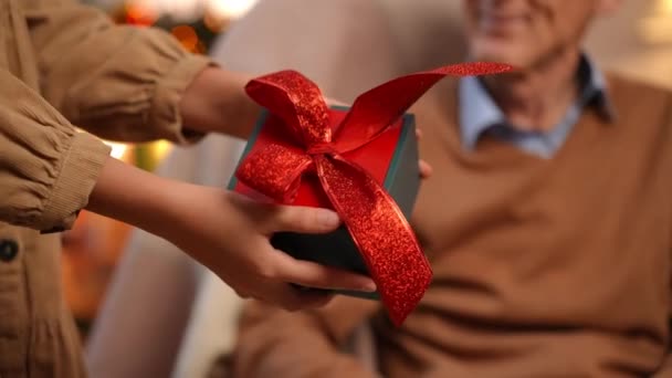 Close Doorgeven Van Kerstcadeau Van Tienermeisje Aan Senior Man Binnen — Stockvideo
