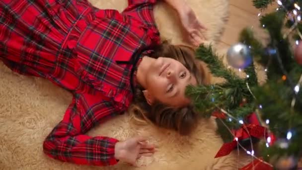Draufsicht Fröhliches Teenager Mädchen Das Sich Unter Den Weihnachtsbaum Legt — Stockvideo