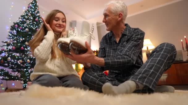 令人惊讶的是 年少无知的孙女在新年前夜在室内感谢爷爷送的冰鞋 兴奋的白人少女拥抱着男人为圣诞礼物感到高兴的画像 — 图库视频影像
