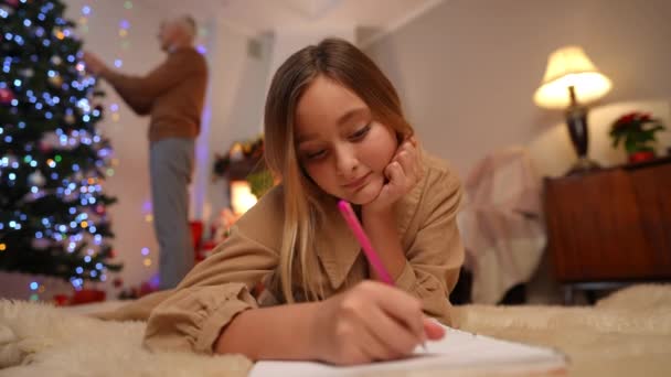 Teenage Girl Writing Letter Santa Blurred Senior Man Decorating Christmas — Stock Video