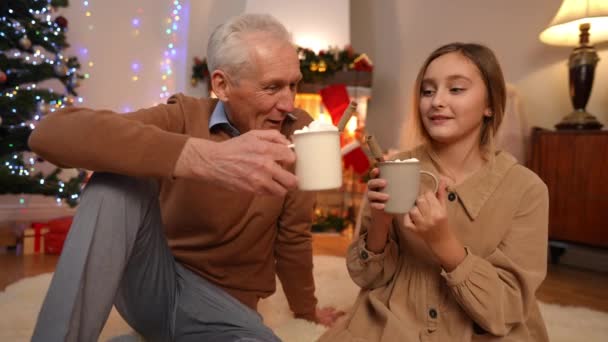 Glückliche Enkelin Und Großvater Trinken Leckeren Traditionellen Weihnachtskakao Mit Marshmallows — Stockvideo