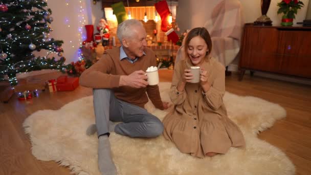 Широко Рассмеявшаяся Девочка Подросток Пожилой Мужчина Наслаждаются Рождественским Какао Зефиром — стоковое видео