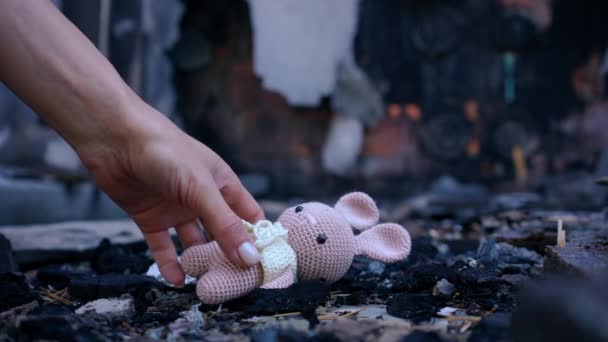 特写镜头中的雌性手在慢慢离开的过程中从粉色儿童玩具中抖掉烟灰 无法辨认的白人年轻女子在乌克兰基辅被轰炸后从地上拿起钩针玩具 — 图库视频影像
