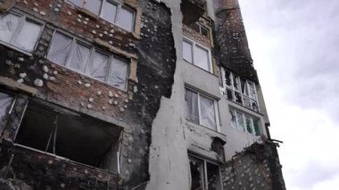 Canlı kamera, bulutlu gökyüzünün arka planındaki yıkılmış ev boyunca hareket ediyor. Kiev Ukrayna 'da yıkılan bombalı konut binasının yaya fotoğrafı. Yavaş çekim
