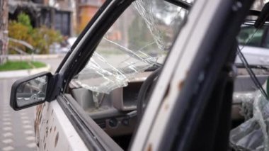 Şehrin dışında cam kırıkları olan bombalanmış bir arabanın yan camı. Ukrayna 'nın Kiev banliyösünde imha edilmiş bir otomobil. Askeri saldırı ve Rus-Ukrayna savaşı kavramı