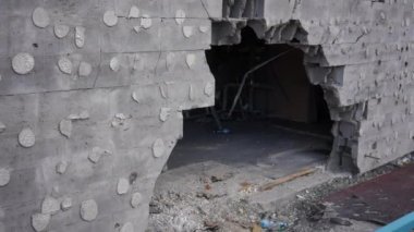 Dışarıdaki kurşun delikleriyle duvardaki delikten metale kadar odaklan. Bombalanmış Ukrayna şehrindeki harabeler. Savaş ve yıkım kavramı