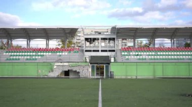 Bombalanmış yorumcu kabininin ve açık hava sporlarında seyirci koltuklarının yayaya oturması. Güneşli bir günde Ukrayna 'da hasar gören mülke geniş açıdan bakıldı. Yavaş çekim