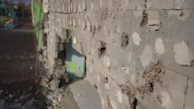 Duvarda topçu delikleri ve arka planda bomba deliği var. Kyiv Ukrayna 'da bombalanan hasarlı binanın yan açısı. Yavaş çekim