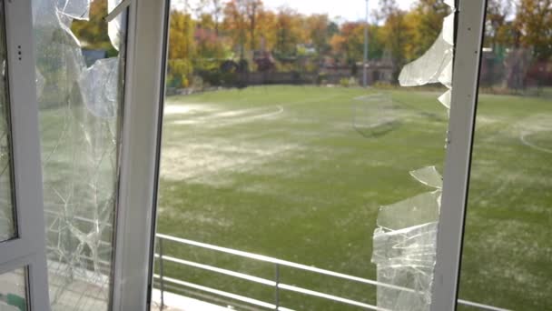キエフウクライナの秋のスポーツフィールド上の荒廃した解説ブースの壊れたガラス 太陽の下での戦争ゾーンの空のスタジアムの内部からの撮影 スローモーション — ストック動画