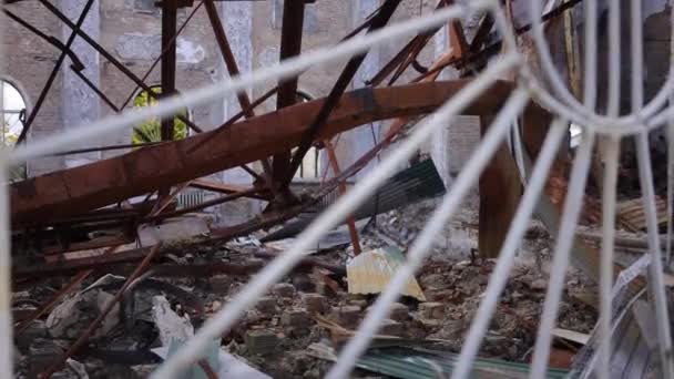 在被炸毁的建筑物的地面上 燃烧摧毁了金属和屋顶石板 在乌克兰基辅 从白色围栏后面射击 残破的财产是室外残余物 — 图库视频影像