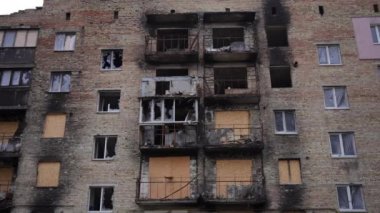 Açık havada yıkık dökük bir binada camları olmayan geniş açılı balkonlar ve pencereler. Cephe manzarası Ukrayna 'nın Kyiv banliyösündeki sivil sarayı bombaladı. Savaş konsepti