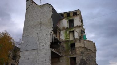 Gökyüzünün arka planında duvarları olmayan çok katlı harap bir bina. Rusya-Ukrayna savaşında sivil mülke zarar verdi. Yavaş çekim