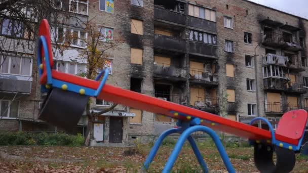 在城市里 被毁的住宅房屋和被粉刷过的阳台 在孩子们的操场上摇摇晃晃 动作缓慢 乌克兰被轰炸城镇没有人在户外 — 图库视频影像