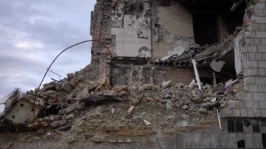 Ukrayna 'nın Kiev banliyösünde yıkılan çok katlı sivil bina duvarı. Arka planda bulutlu gökyüzü olan kentsel şehirde arta kalan mallar. Yavaş çekim