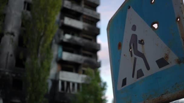 城市街道上被炸毁的住宅大楼后面有弹孔的特写路标 乌克兰基辅的行人过街天桥 室外民房被拆毁 — 图库视频影像