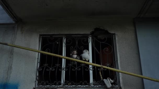 Ashed Niños Juguetes Colgando Rejilla Metal Ventana Casa Ruinas Aire — Vídeo de stock