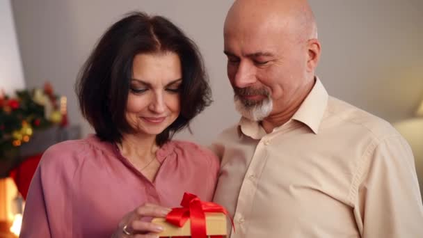 Красива Жінка Відкриває Різдвяний Подарунок Світлом Всередині Цілує Усміхненого Чоловіка — стокове відео