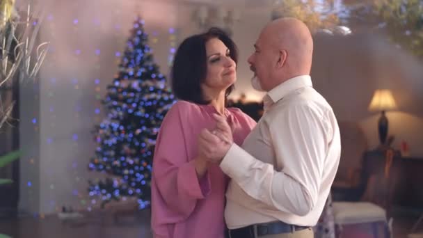 新年前夕 一对恋人在客厅里跳舞 透过窗户射击 在家里欢度圣诞的白种人和女人笑着享受闲暇 — 图库视频影像