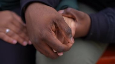 Yakından Afrika kökenli Amerikalı erkek avuçlarını okşuyor. Dışarıda flört eden bir kadının parmaklarını okşayan tanınamaz bir adam. İlişki ve aşk kavramı