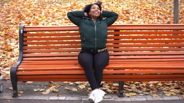 Широкий Постріл Розслаблено Усміхаючись Молодій Жінці Сиділа Лавці Осінньому Парку — стокове відео